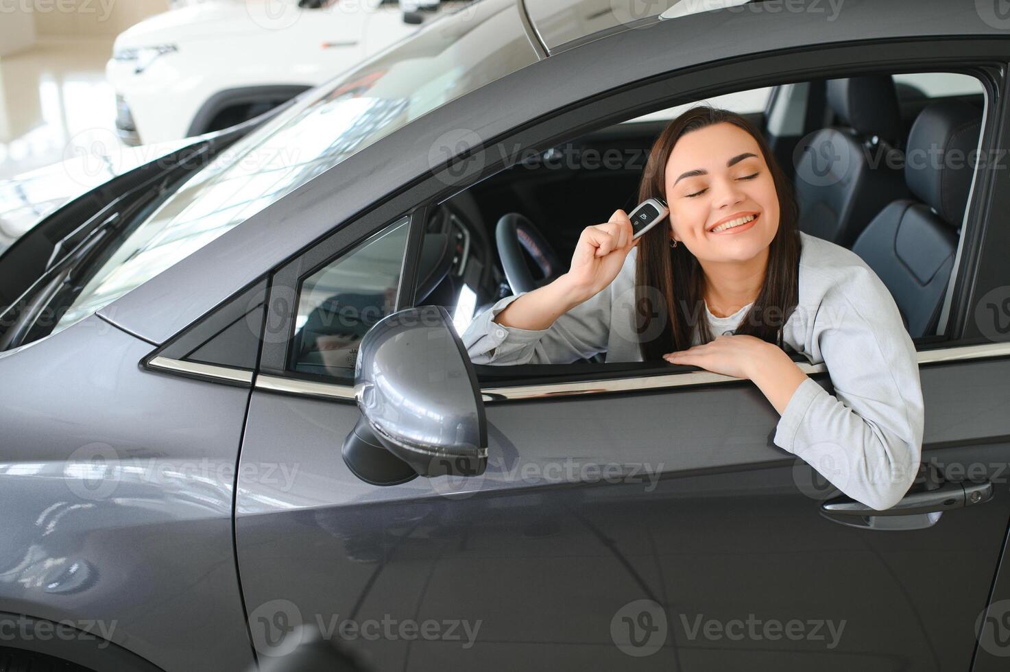 Photo of happy young woman sitting inside her new car. Concept for car rental