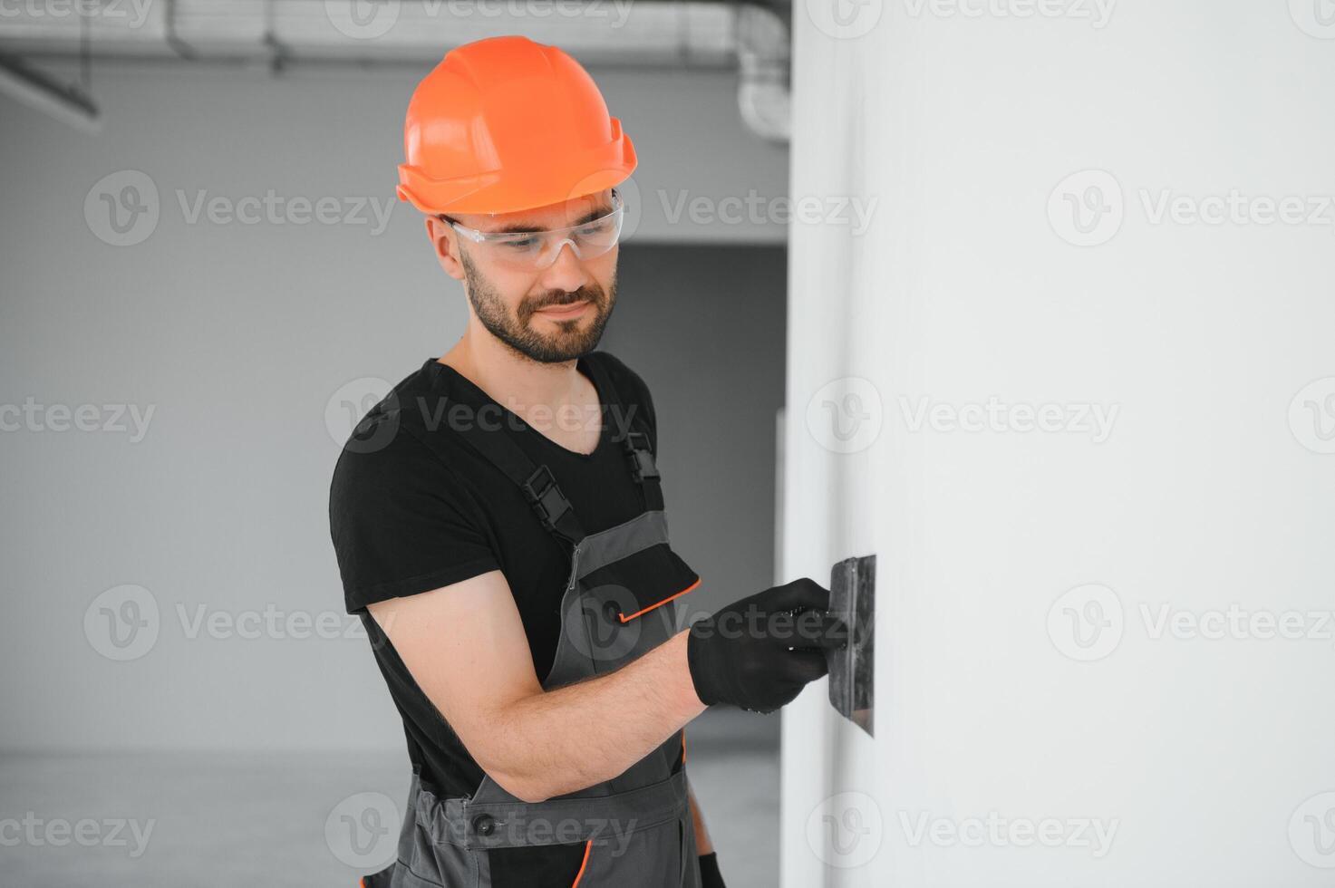man drywall worker or plasterer putting mesh tape for plasterboard on a wall using a spatula and plaster. photo
