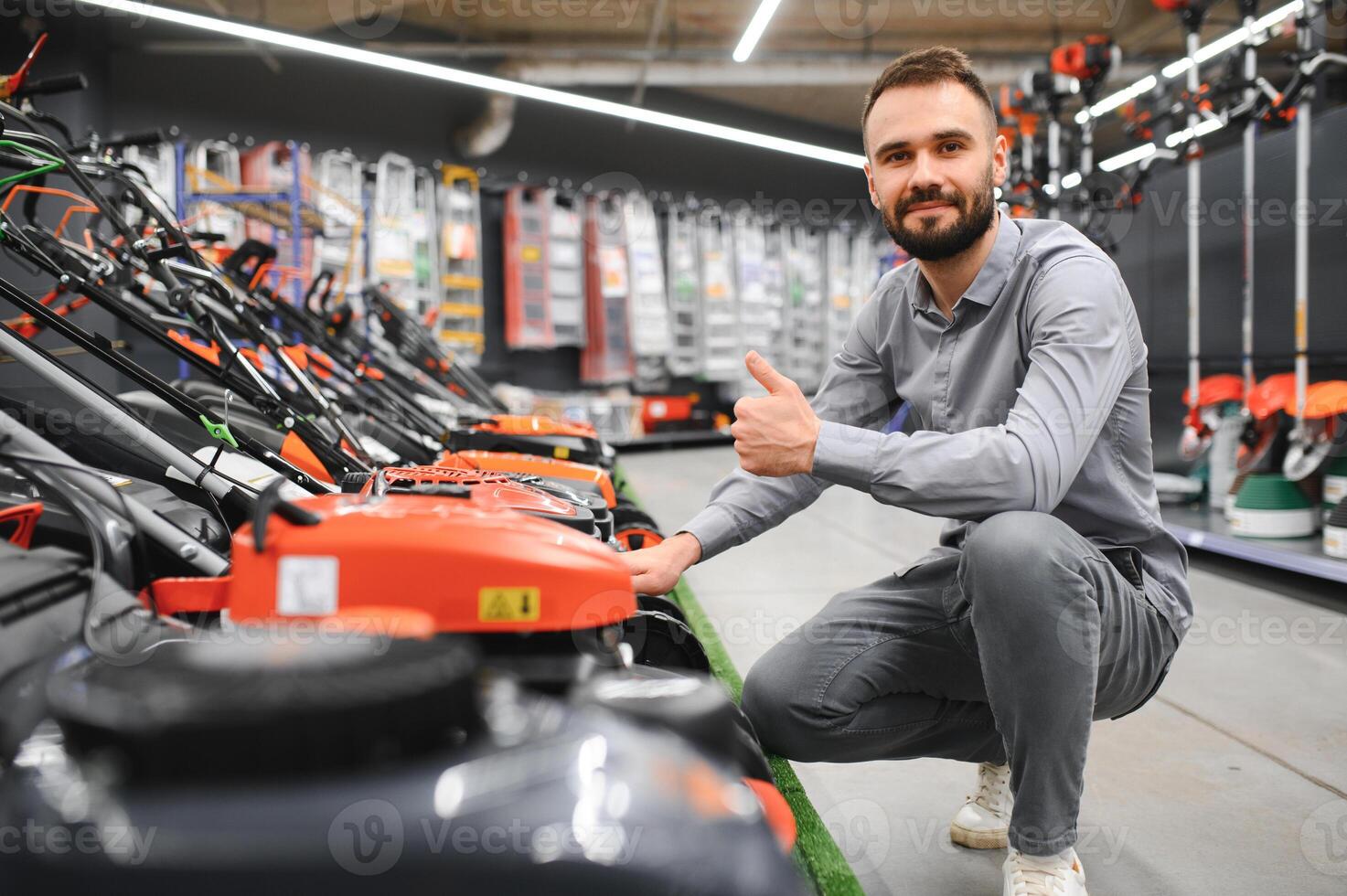 a customer examines new models of lawn mowers in an electrical store for gardeners and horticulturists photo
