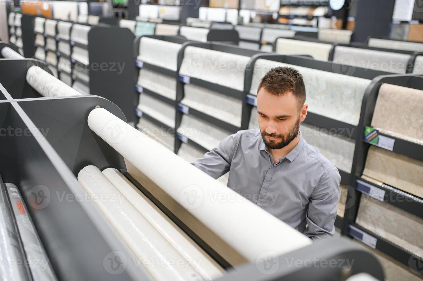 a man chooses wallpaper for pasting walls in a hardware store photo