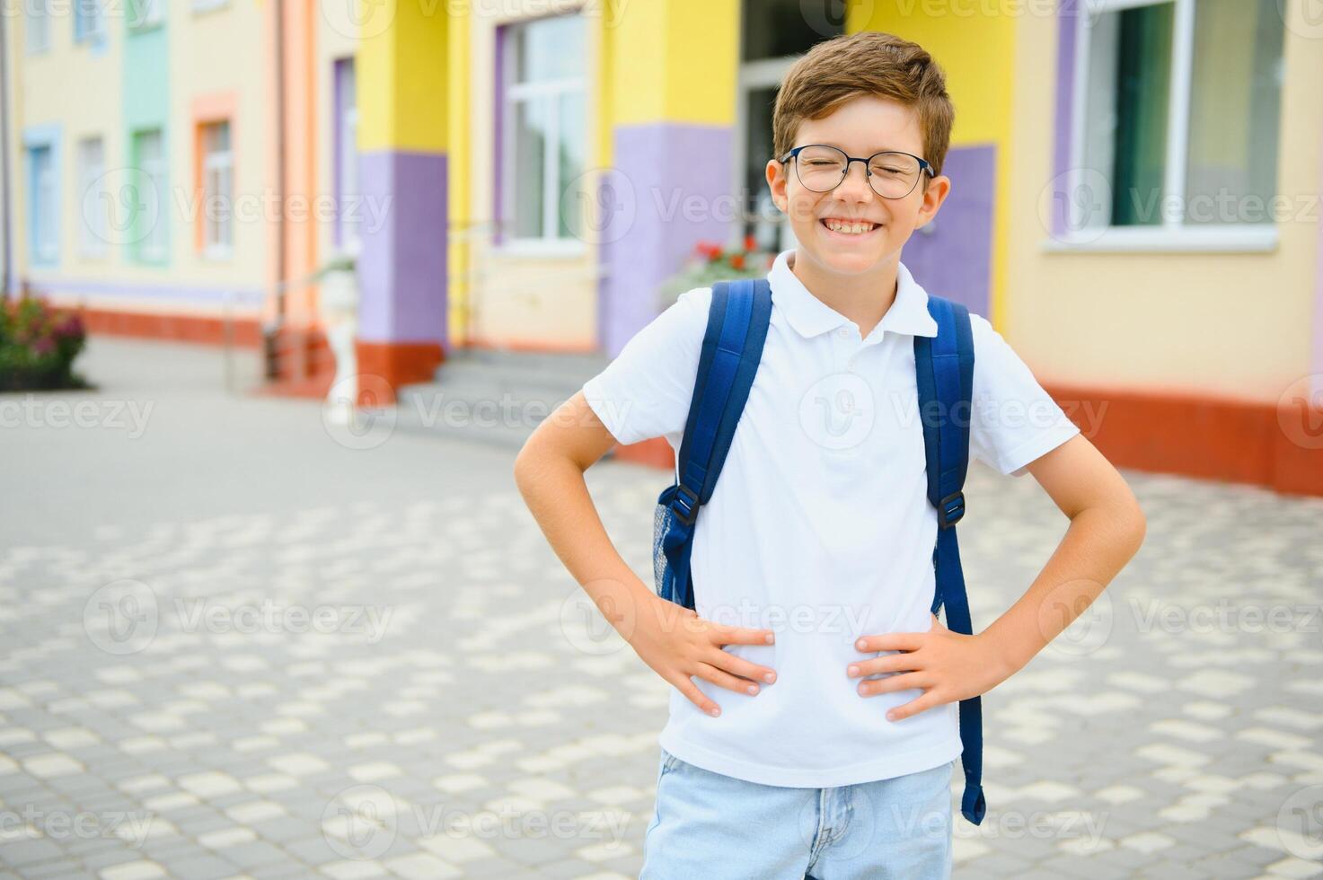 Back to school. Pupil of primary school on the way to study. Little first grader in glasses and with school bag photo