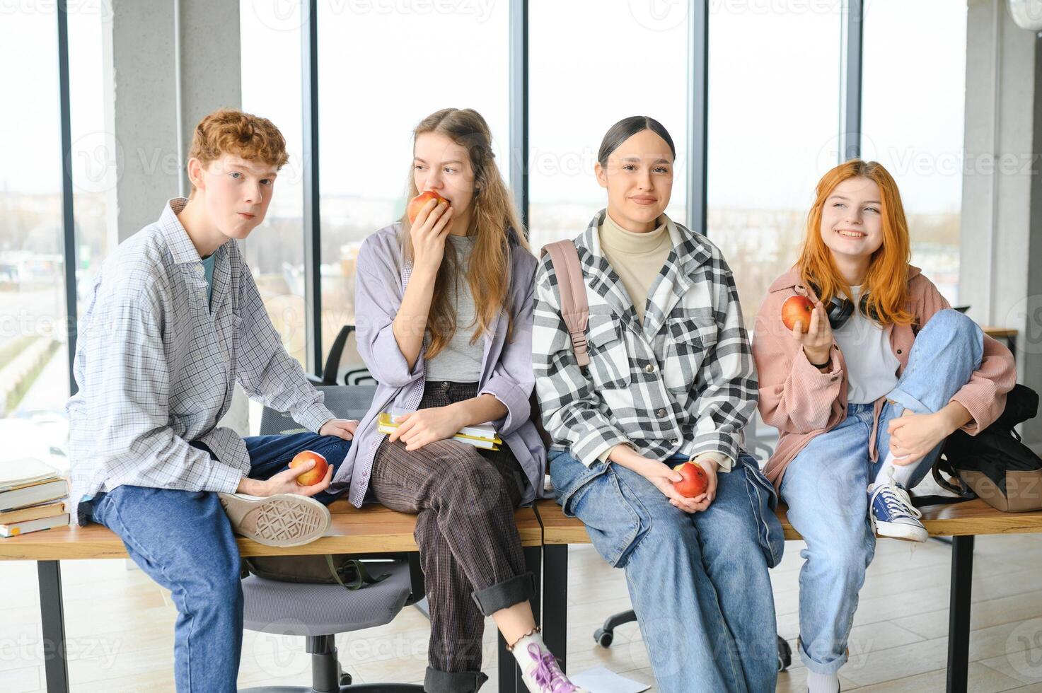 education, food, people and friendship concept, group of happy students eating apples photo