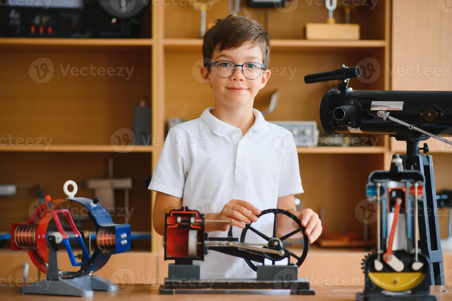 Physics lesson. A student at a desk with scientific instruments and a telescope photo
