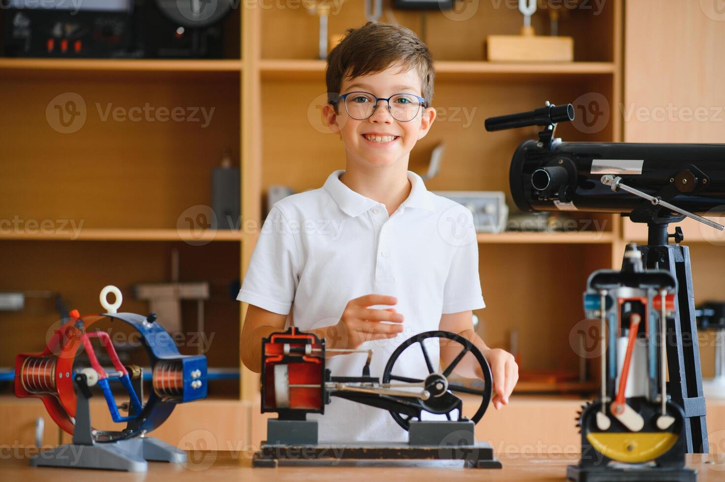 Physics lesson. A student at a desk with scientific instruments and a telescope photo