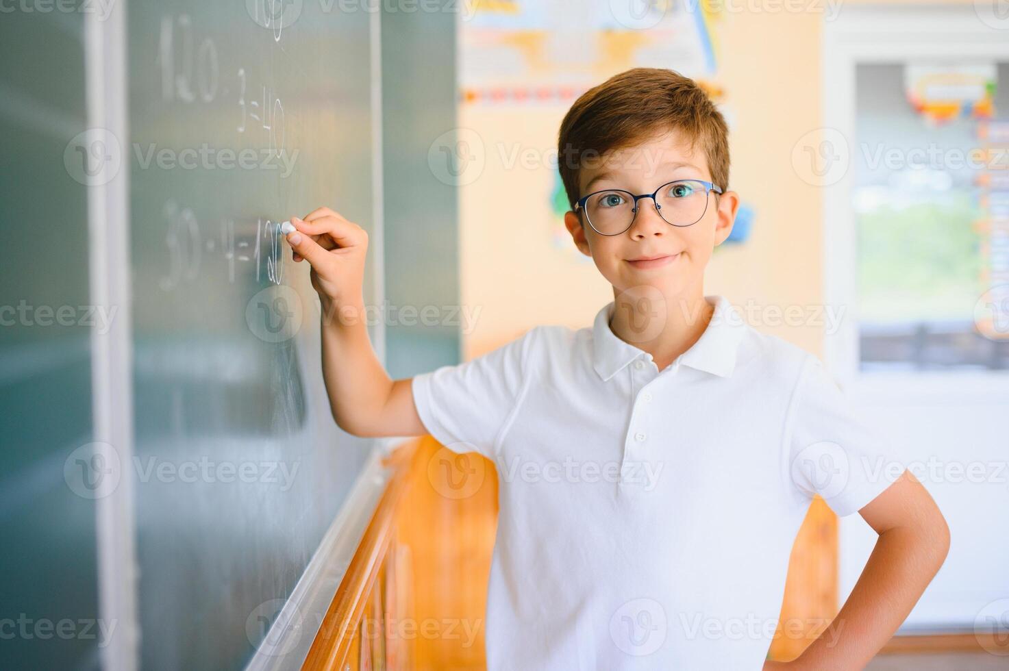 Schoolboy near blackboard in classroom photo