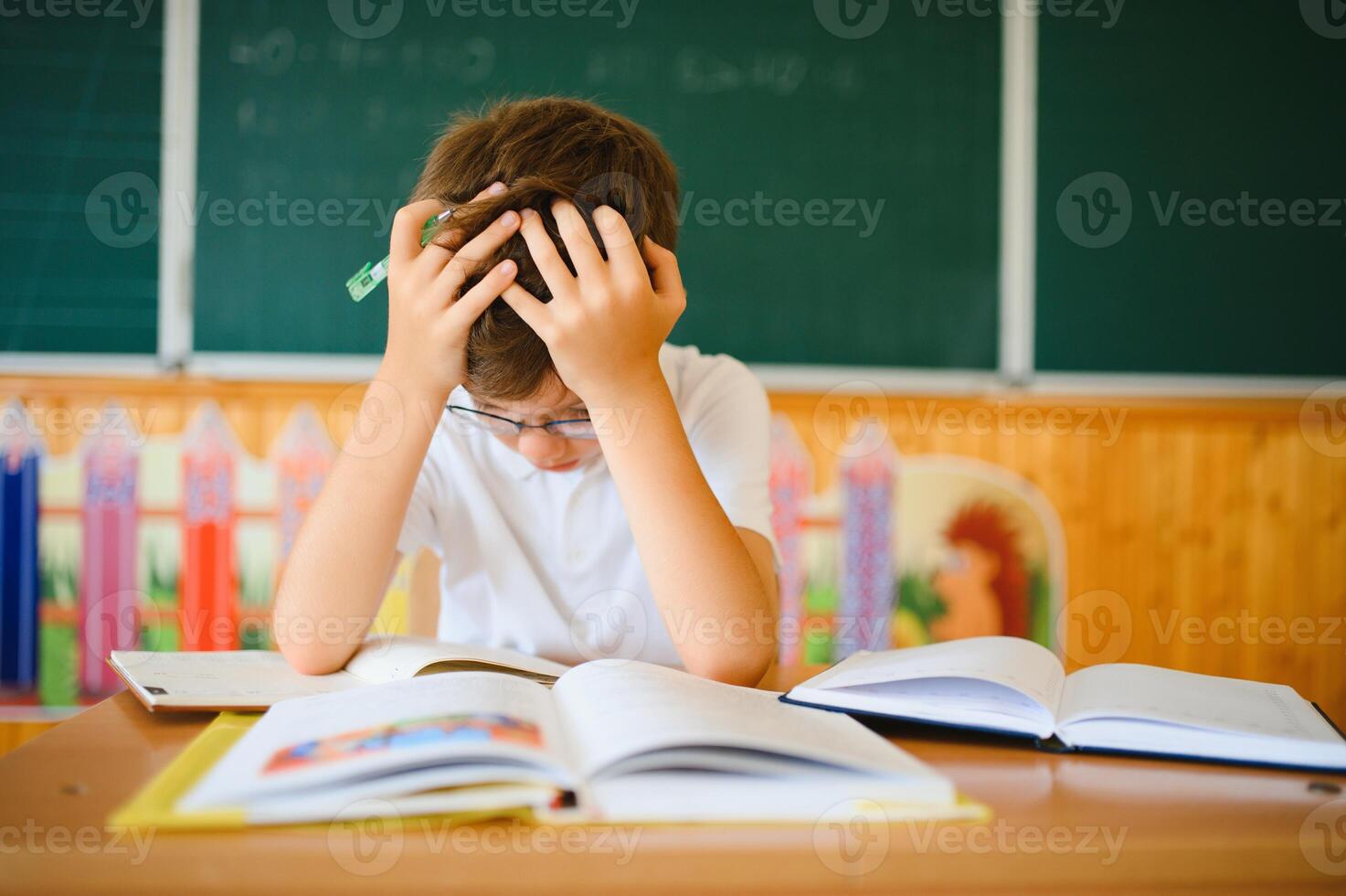 Portrait of little boy studying in classroom at school photo