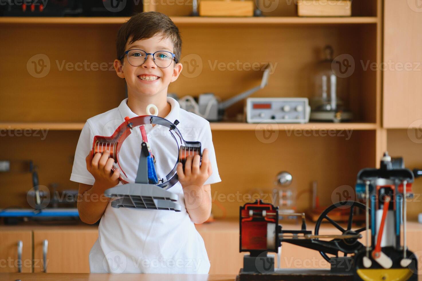 Physics lesson. A student at a desk with scientific instruments and a telescope photo