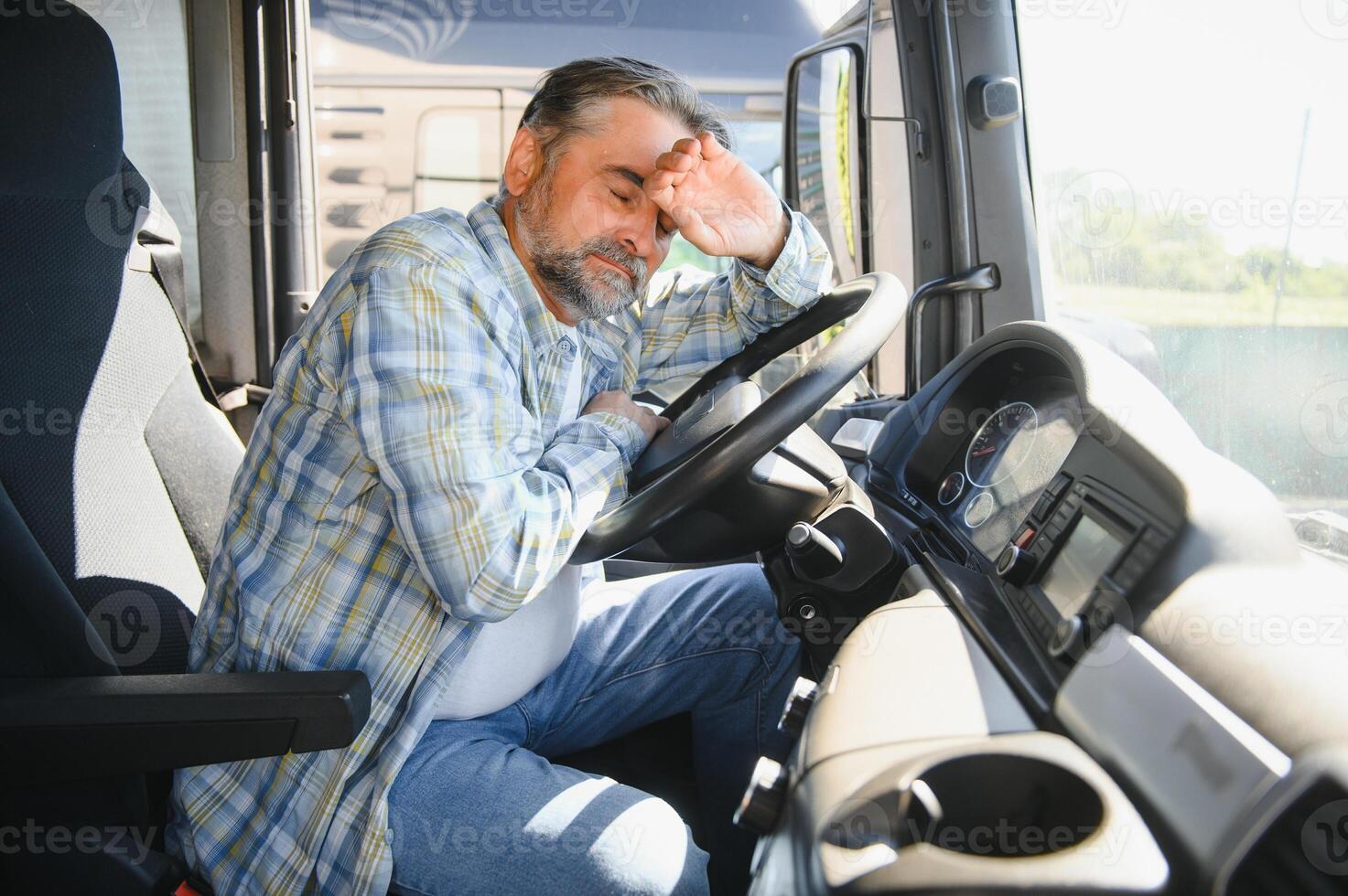 Exhausted truck driver falling asleep on steering wheel. Tiredness and sleeping concept photo