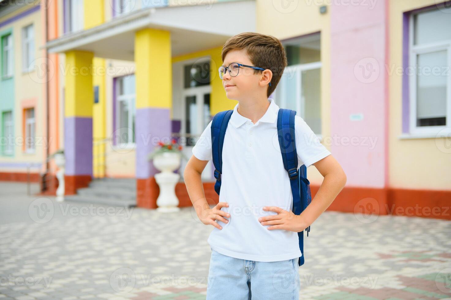 Back to school. Pupil of primary school on the way to study. Little first grader in glasses and with school bag photo
