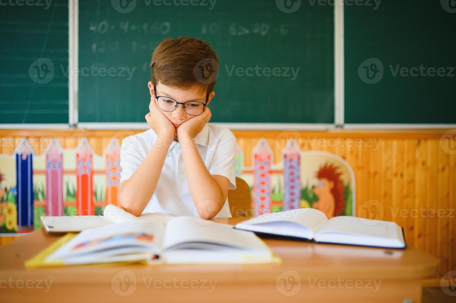Portrait of little boy studying in classroom at school photo