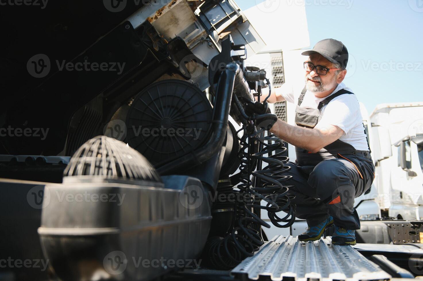 A senior worker checks wheel. Truck malfunction. Service work photo