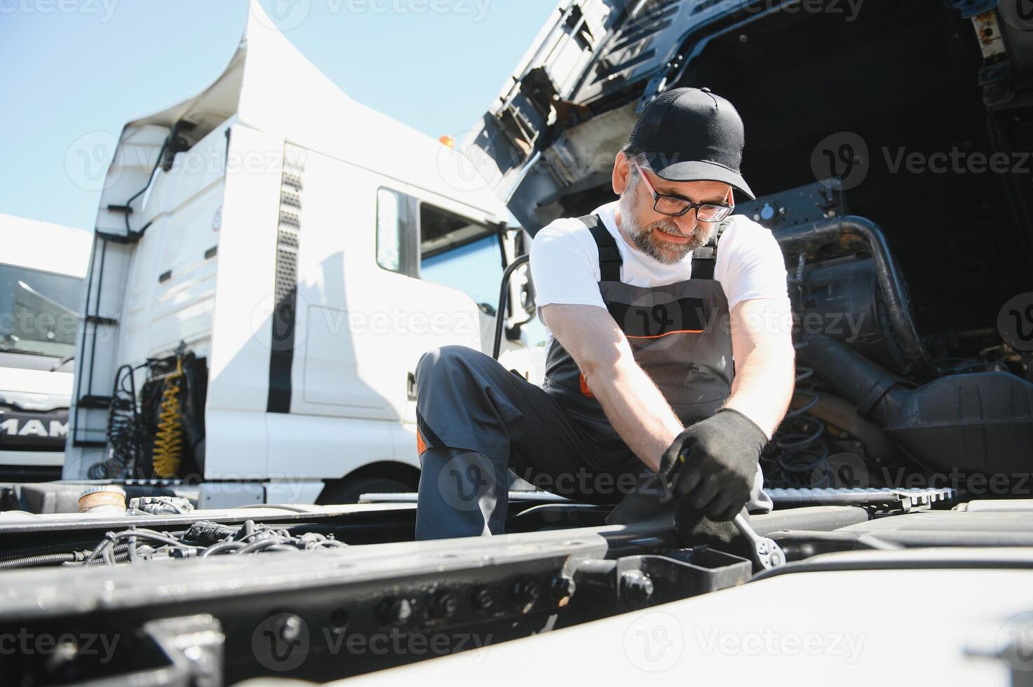 A senior worker checks wheel. Truck malfunction. Service work photo