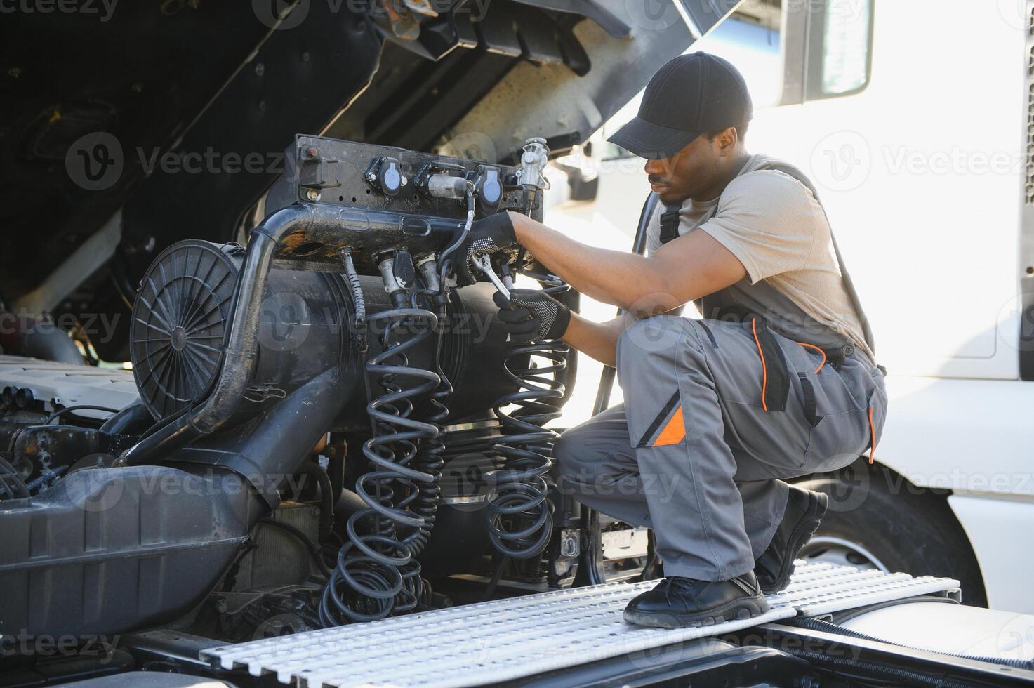 Professional truck mechanic working in vehicle repair service photo