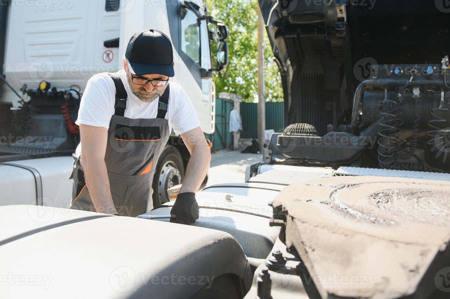 A senior worker checks wheel. Truck malfunction. Service work photo