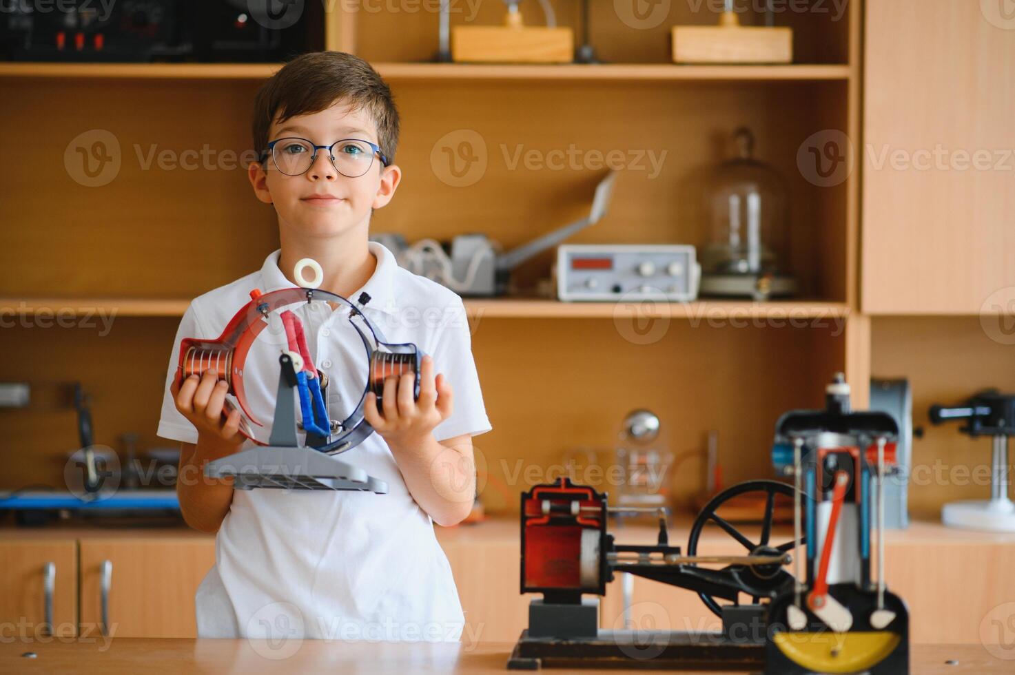 Physics lesson. A student at a desk with scientific instruments and a telescope photo