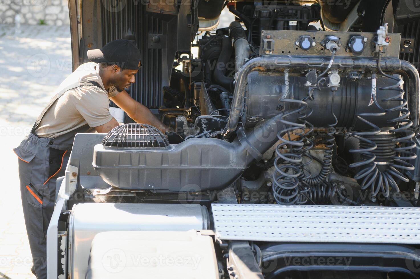 African american Professional Truck Mechanic Rebuilding Heavy Duty Truck Diesel Engine. Automotive Industry Theme photo