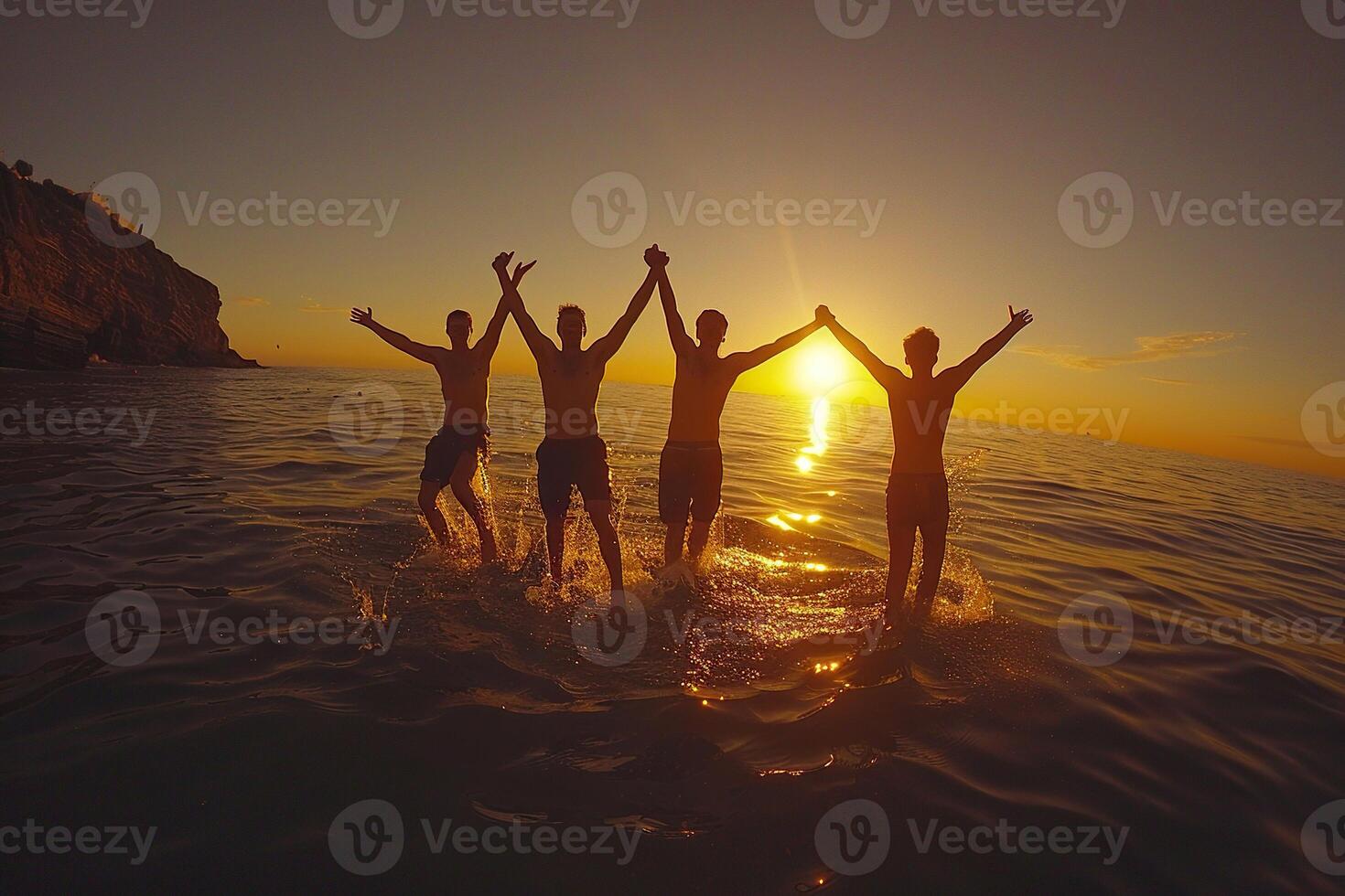 Four friends jumping into the water holding hands at sunset. Concept of friendship and fun. photo