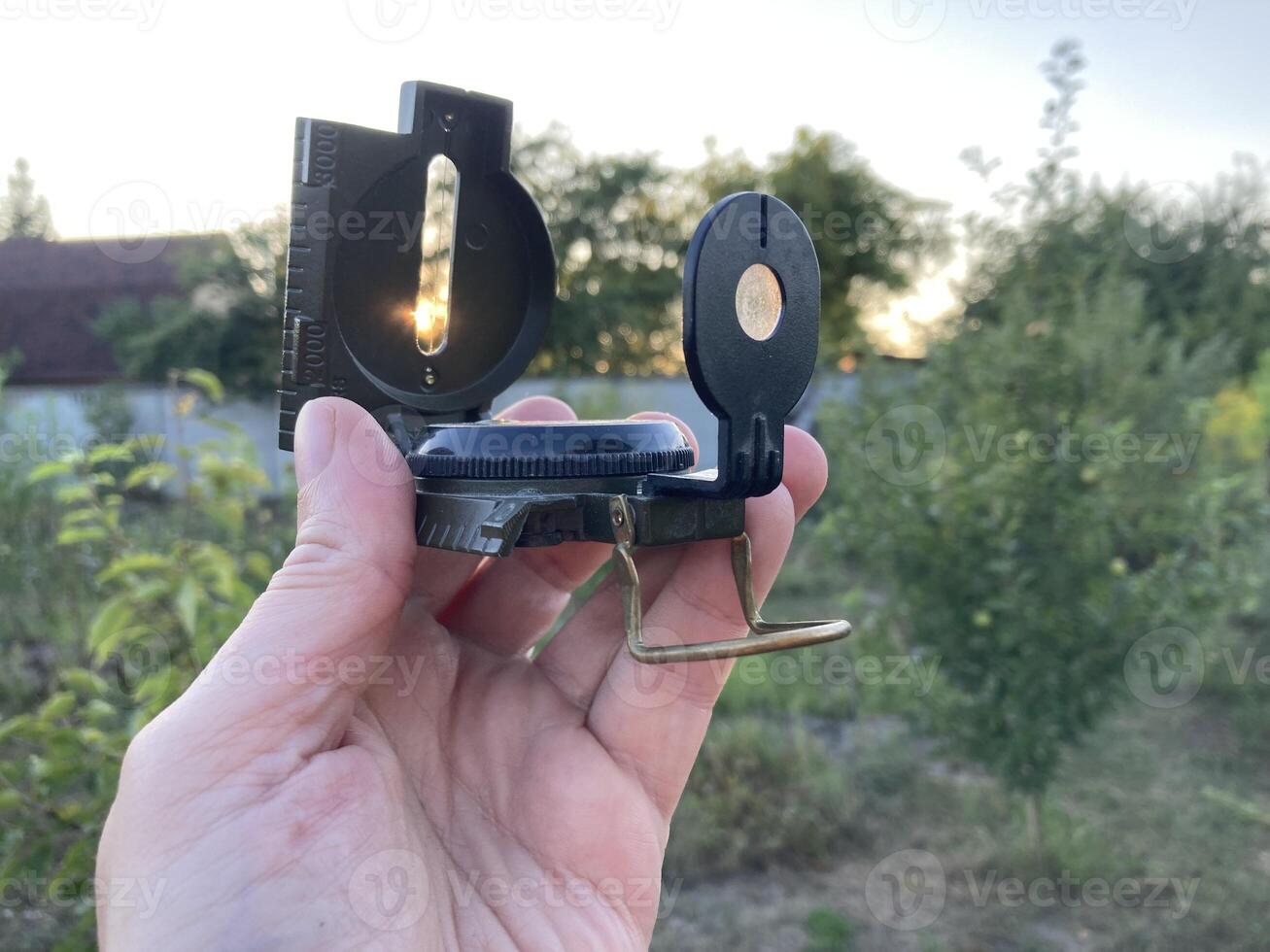 Compass for orientation on the terrain during a hike photo
