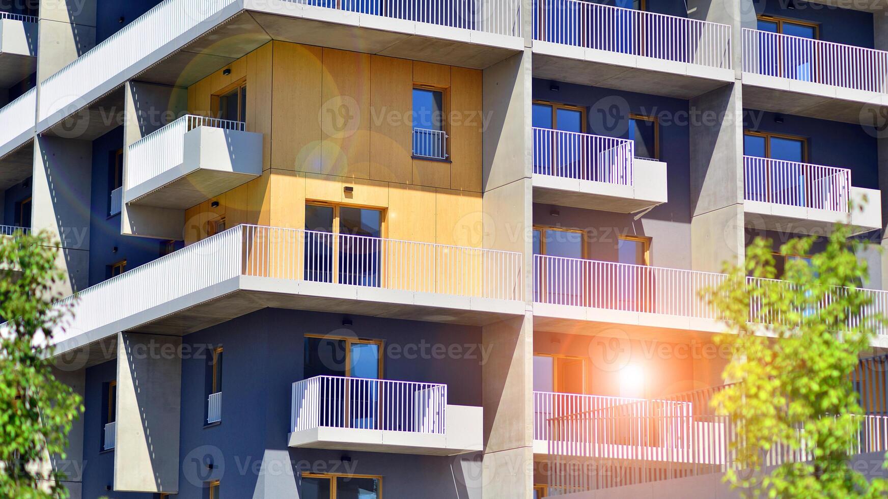 New modern block of flats in green area. Eco apartment building saving energy and fresh air concept. Green tree and new apartment building. The harmony of nature and modernity. photo