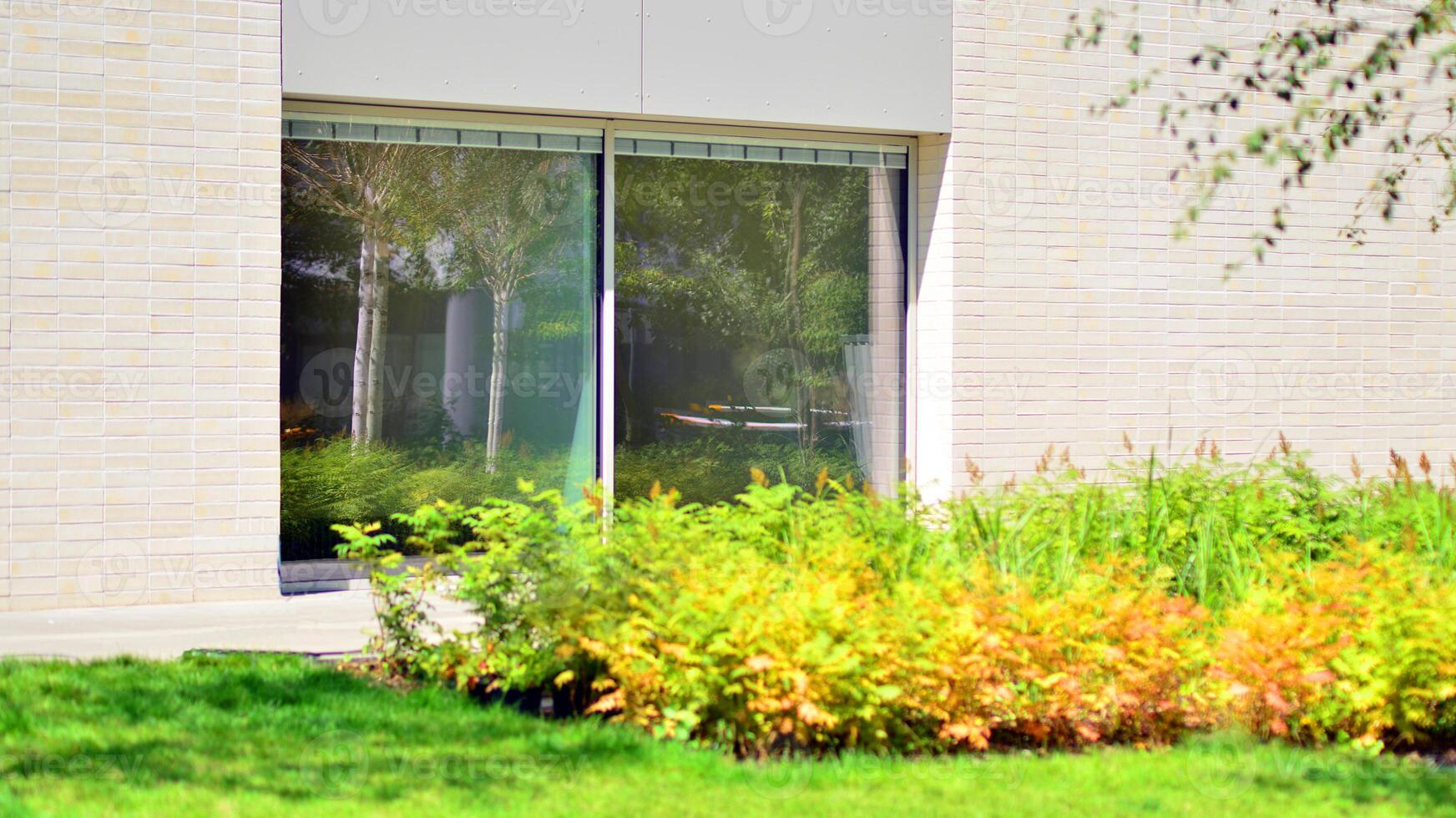 New modern block of flats in green area. Eco apartment building saving energy and fresh air concept. Green tree and new apartment building. The harmony of nature and modernity. photo
