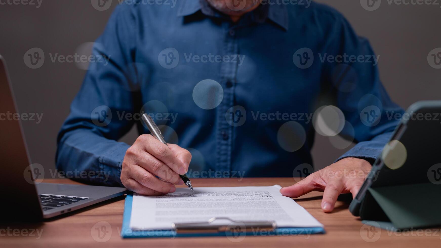 Businessman signs contract in his office, sealing his success in business management, with paperwork and documents neatly arranged, representing his attention to detail and professional commitment. photo