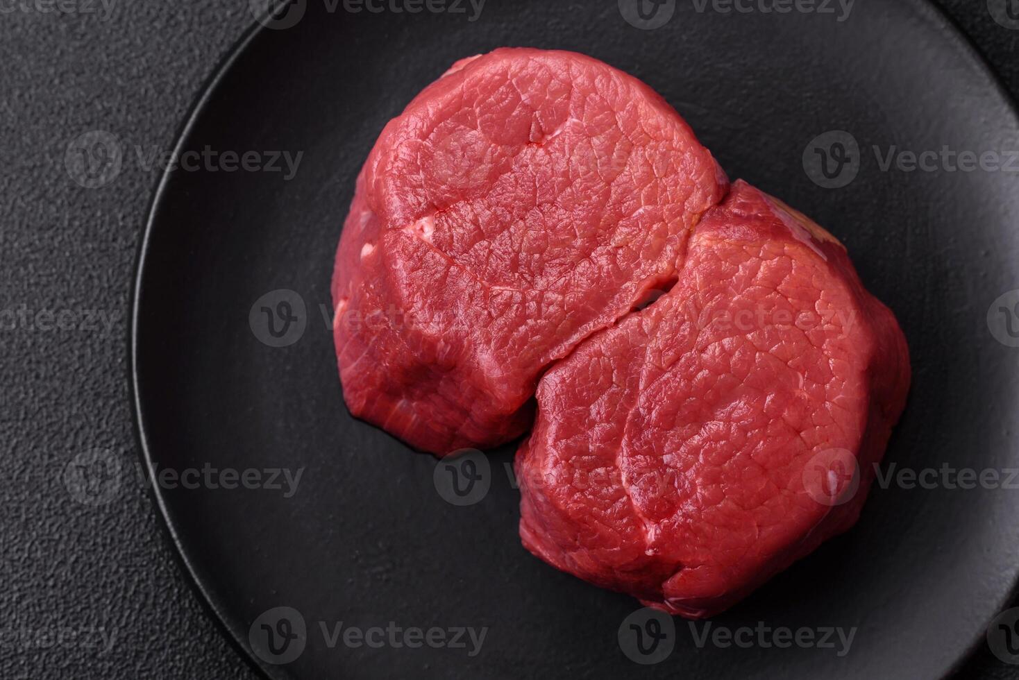 Fresh juicy raw beef medallions with salt and spices photo