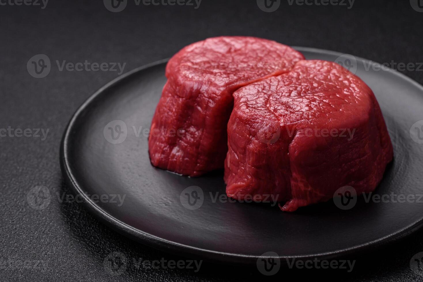 Fresh juicy raw beef medallions with salt and spices photo