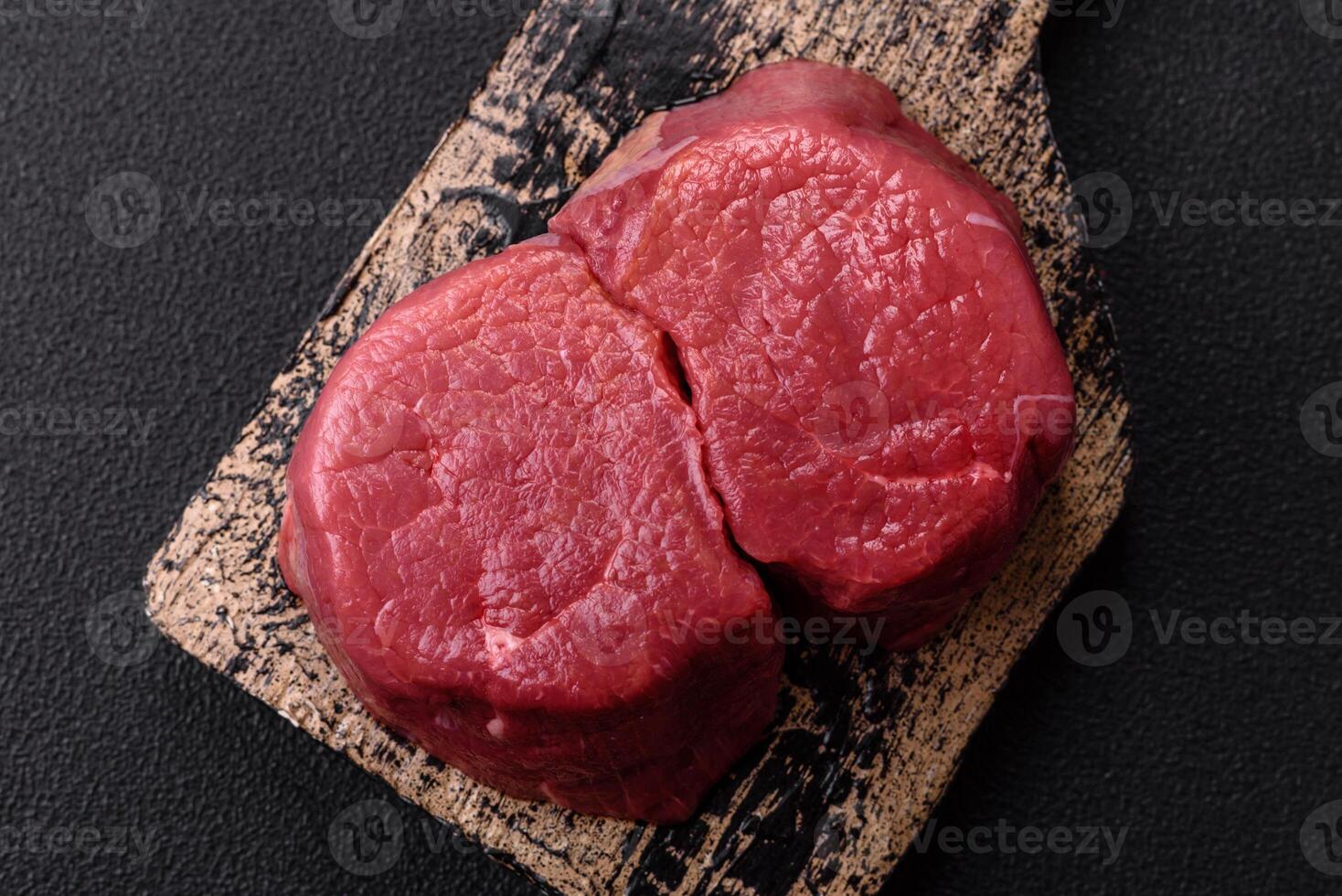 Fresh juicy raw beef medallions with salt and spices photo