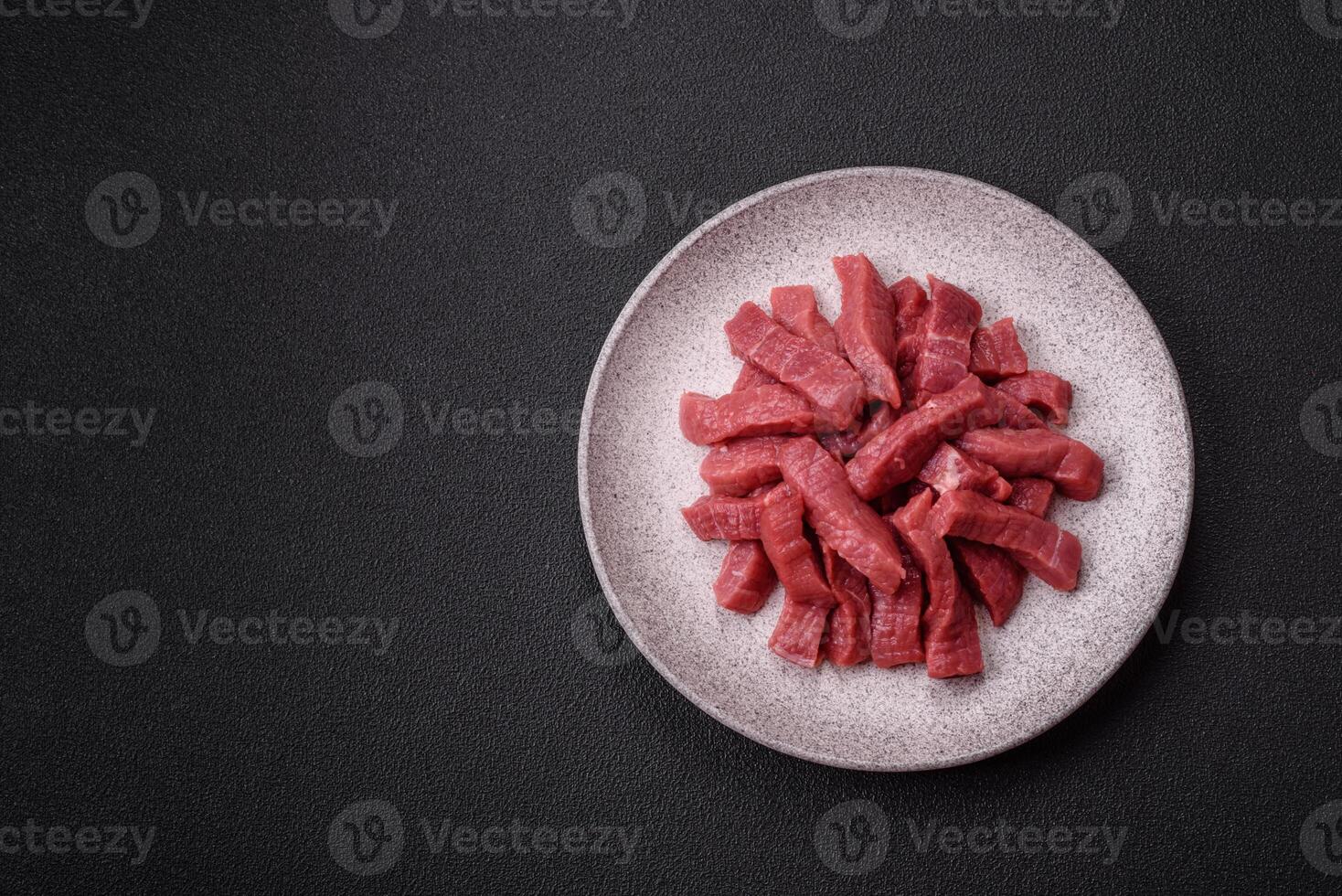 Juicy fresh raw beef meat with salt, spices and herbs photo