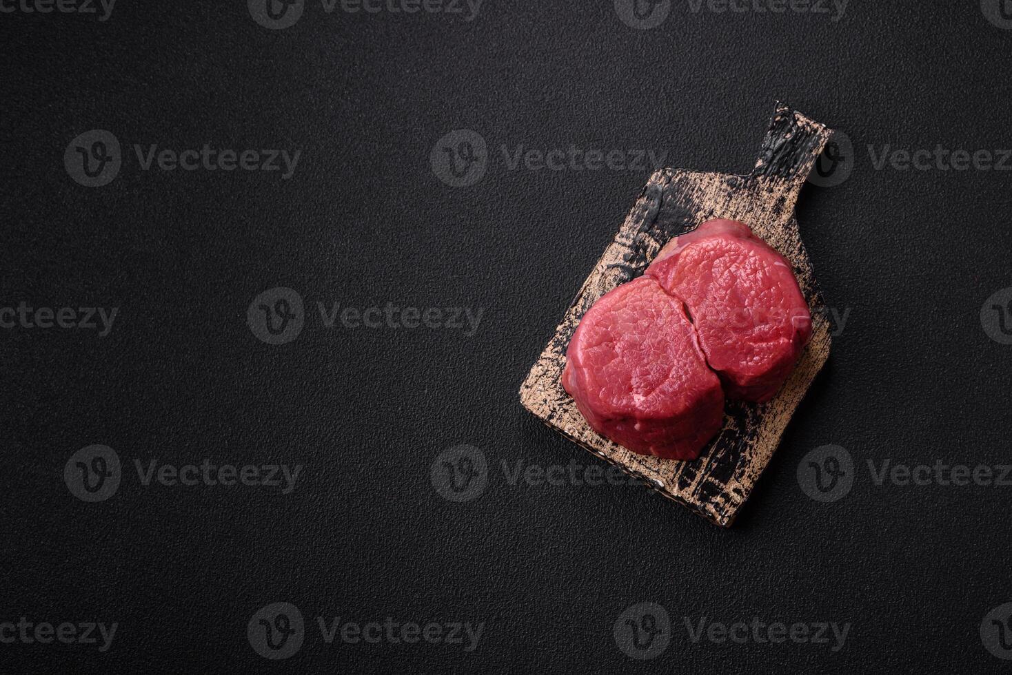 Fresh juicy raw beef medallions with salt and spices photo