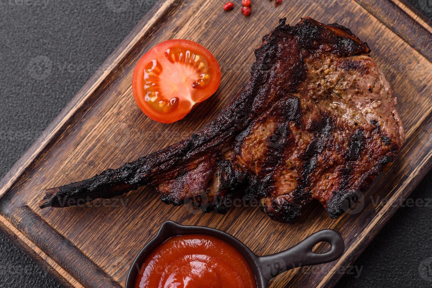 Juicy grilled beef tomahawk steak with salt, spices and herbs photo