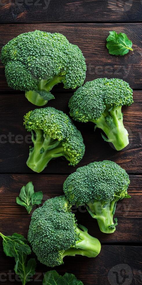 Fresh broccoli bunches on a wooden table in natural light photo