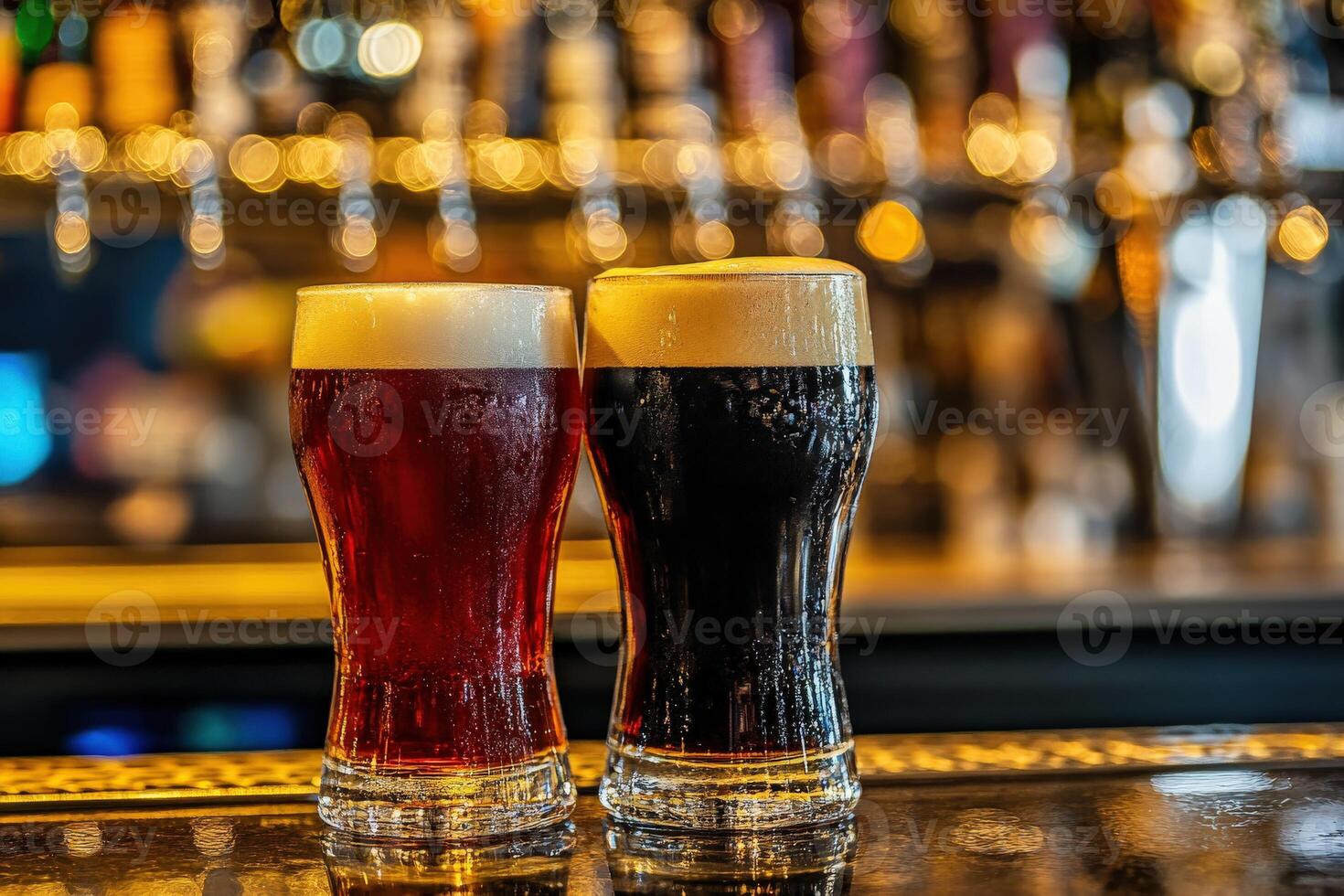 Two glasses of dark and light beer on a bar counter at night photo