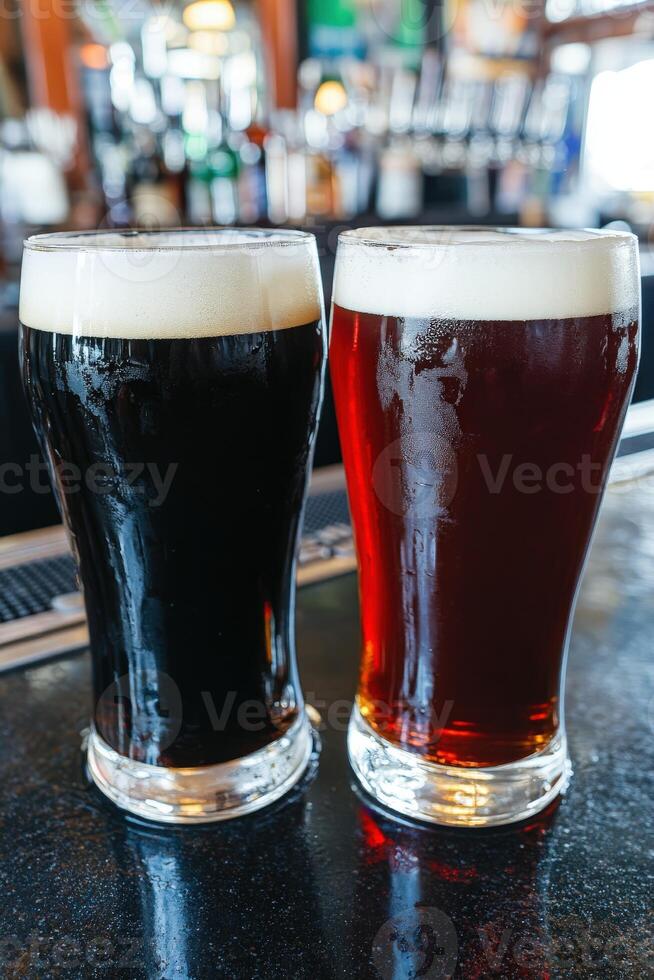 Two glasses of dark and light beer on bar counter in lively pub photo