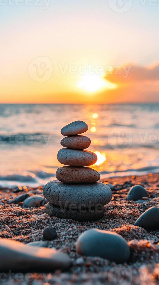 Stacked zen stones on a beach at sunset photo