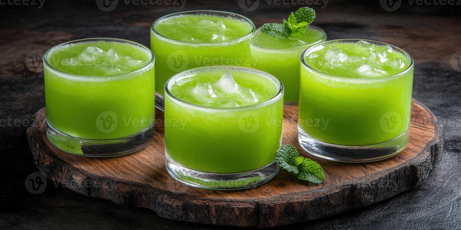 Refreshing green mint lemonade with ice in glasses on a wooden board photo