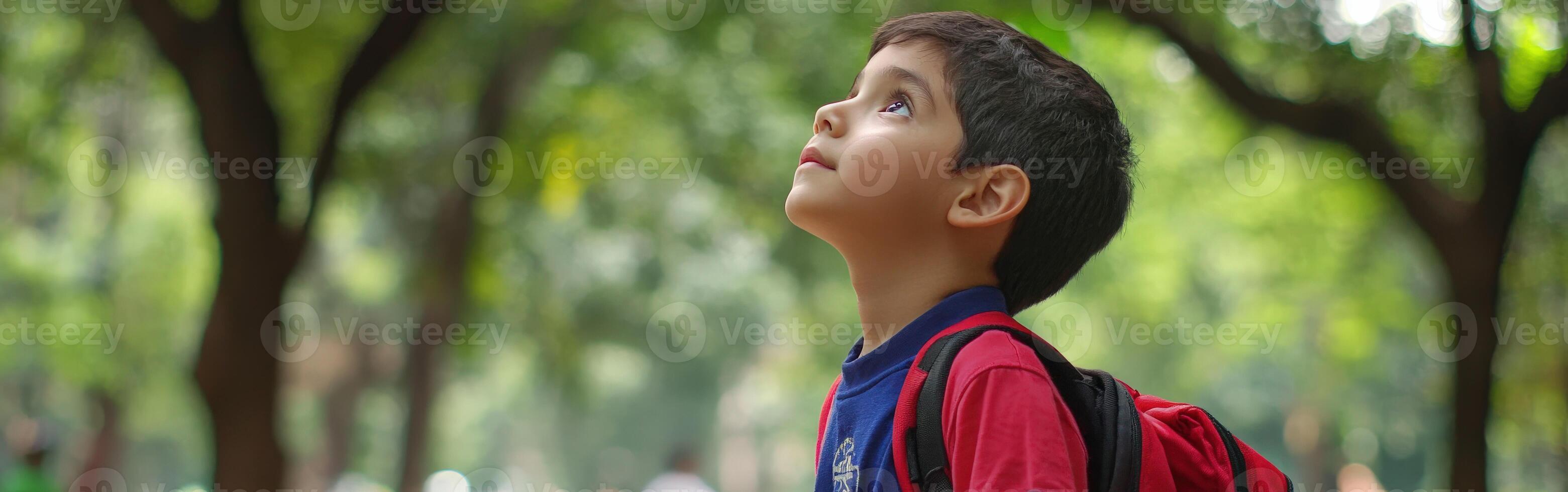 High school boy gazing at the cloudy sky in a park during afternoon photo