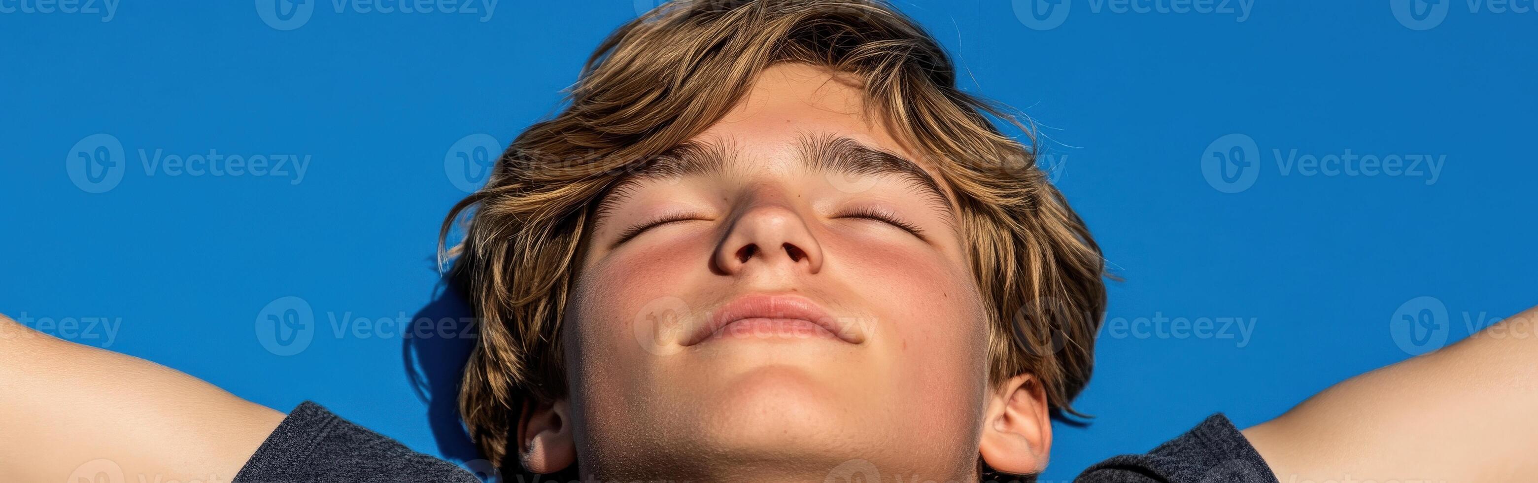 High school boy enjoying a sunny day while gazing at the sky photo