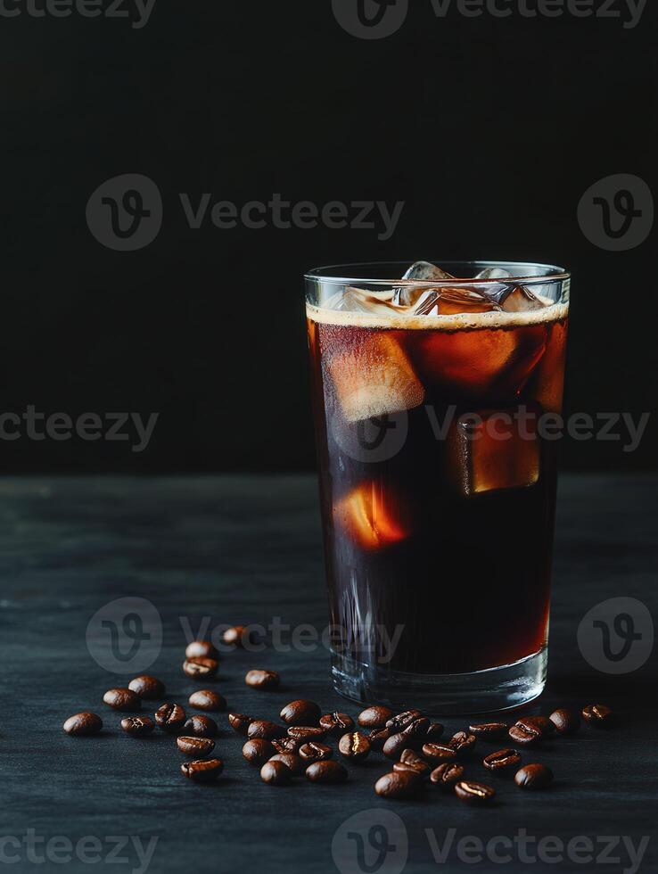 Refreshing iced coffee with cream and coffee beans on a dark table photo