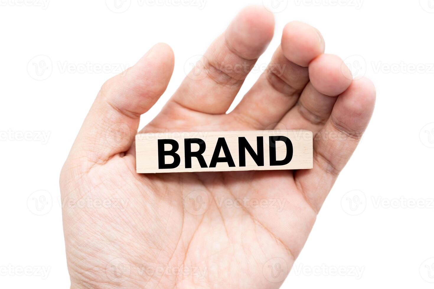 Text BRAND wooden block on hand with Clipping path isolate on white background. Build your Brand. Brand building, success, business. photo