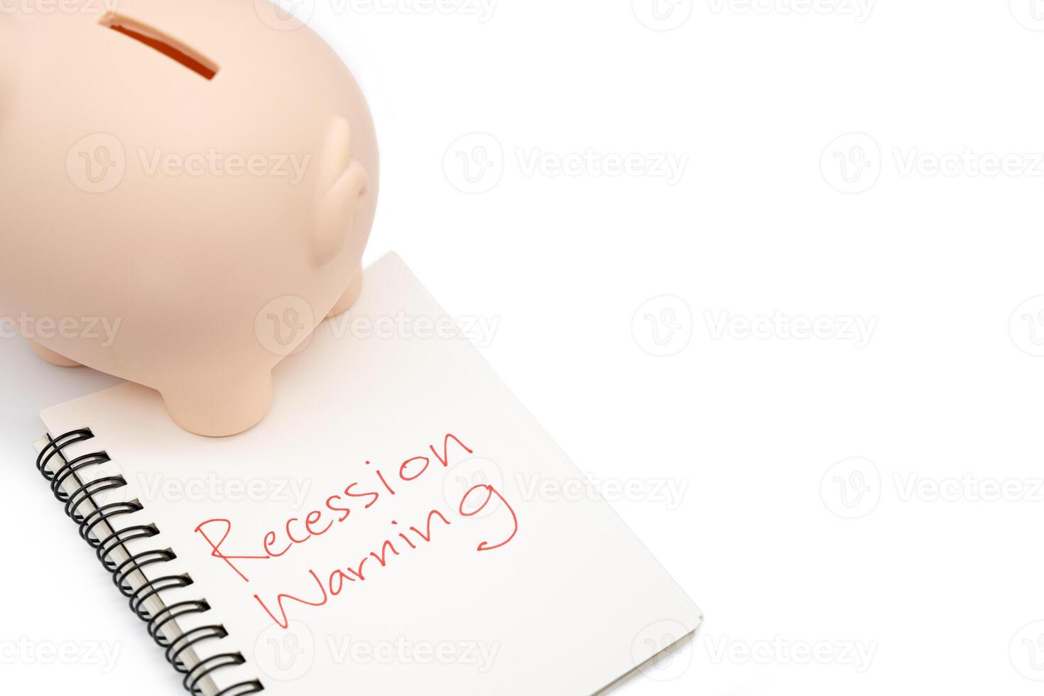 Hand writing Recession Warning on notebook with piggy bank. Global economic crisis. Recession business and stock crisis concept. photo
