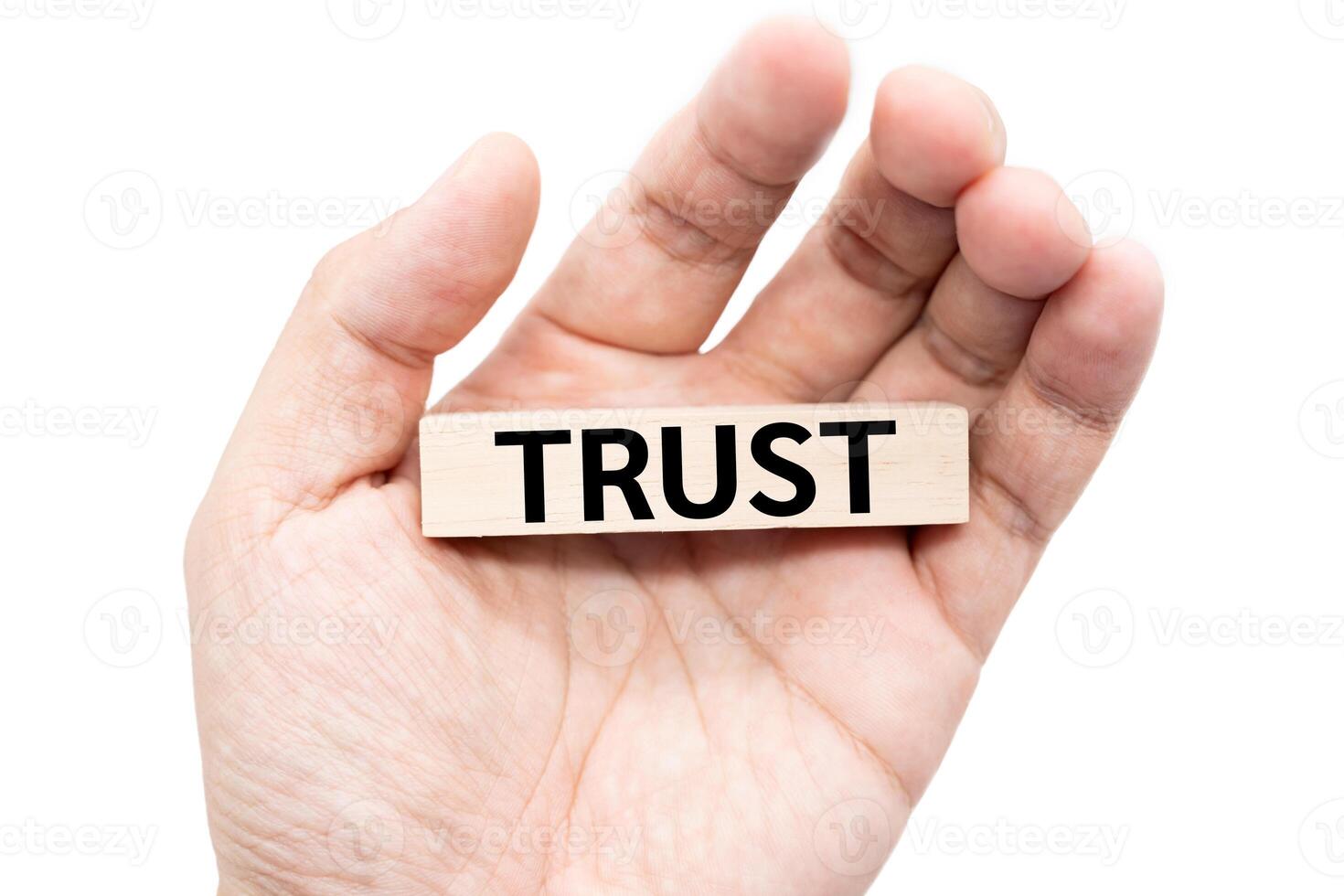 Text TRUST on wooden block on hand with Clipping path isolate on white background. Financial and business concept. Marketing. Brand building. photo
