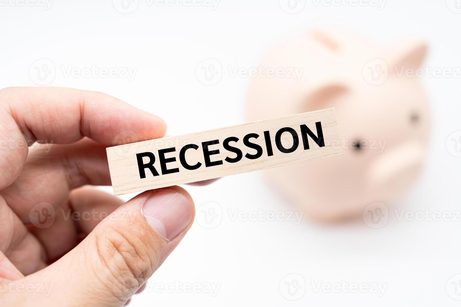 Text RECESSION on wooden block with piggy bank on the background. Financial and business concept. photo