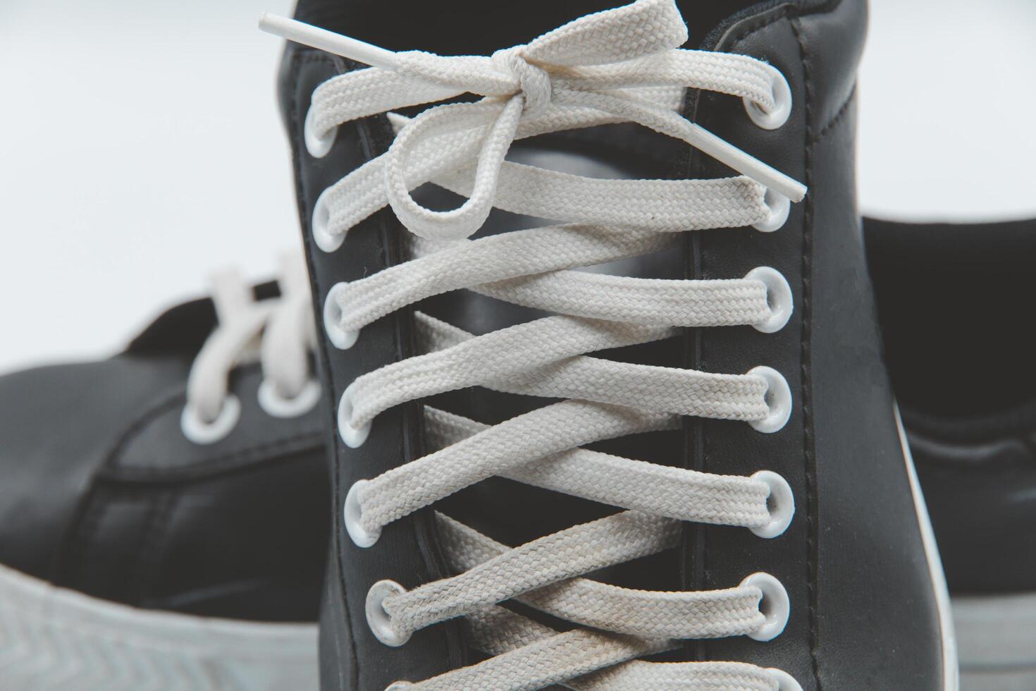 shoe sneaker on white background, close up of sneaker on white background, old black generic sneakers on white background. photo