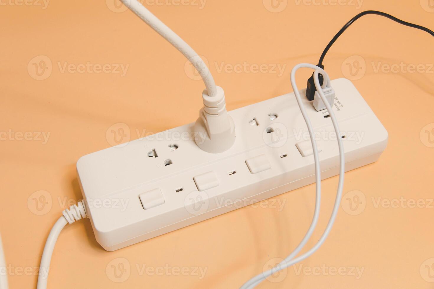 Electrical plug in outlet socket at home, Electrical plug in outlet socket at home, Energy efficiency concept, Power strip with extension cord on beige background, top view. photo