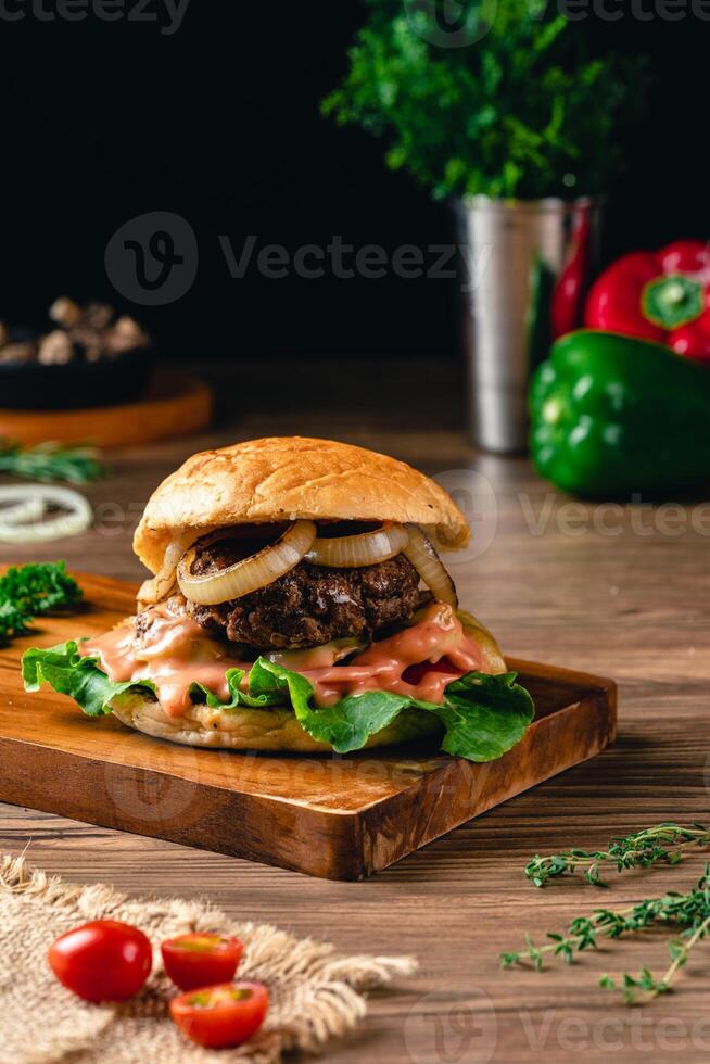 Fresh grilled homemade burgers with beef, tomato, fried egg, cheese and lettuce on rustic wooden background. fast food and junk food concept. photo
