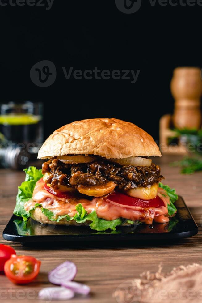 Fresh grilled homemade burgers with beef, tomato, fried egg, cheese and lettuce on rustic wooden background. fast food and junk food concept. photo