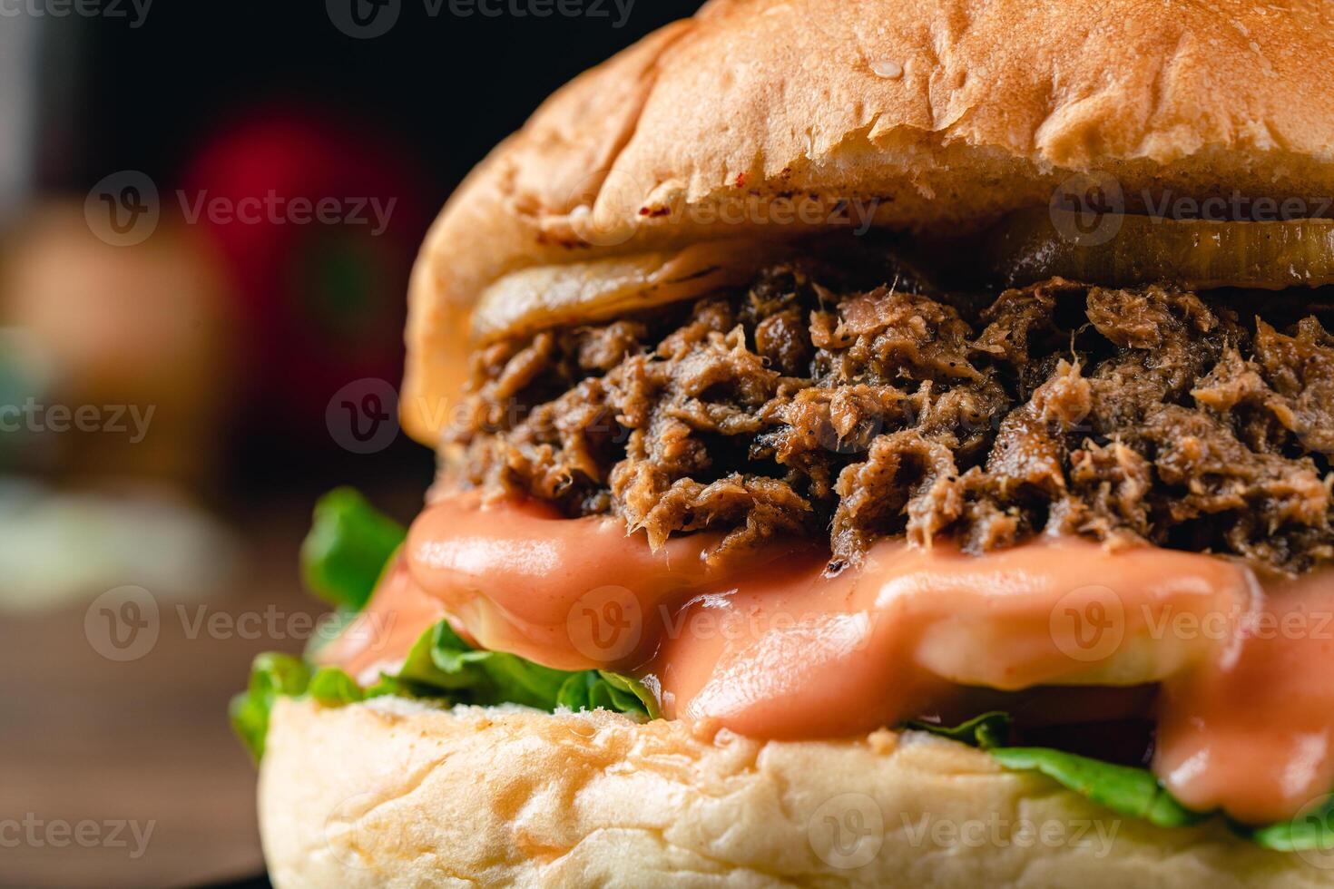 Tasty grilled tuna burger or sandwich with lettuce, tomato, onion rig and mayonnaise served on wooden table. dark mood. photo