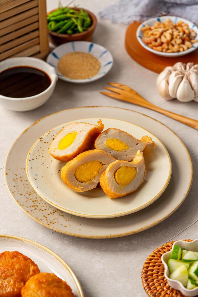 Pempek is a savoury Indonesian fishcake delicacy, made of fish and tapioca from Palembang. Pempek is served with sweet and sour sauce. photo