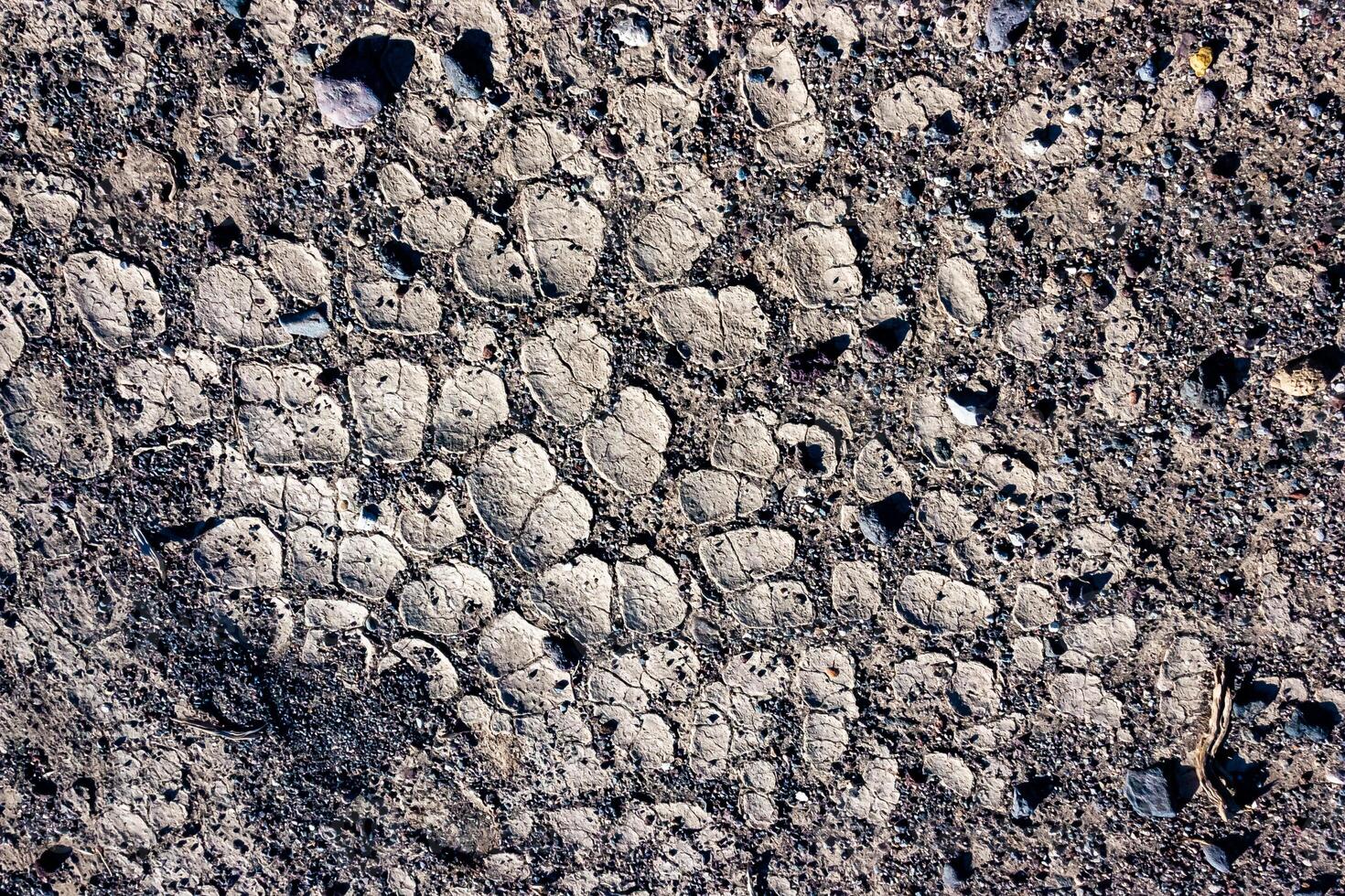 Dry yellow clay cracked in the sun with sand in the Californian desert, Death Valley National Park, California photo